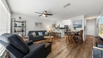 a living room with a couch and a table at West End Coastal Escape Renovated 1BR Condo w Pool Beach Access 72 in Panama City Beach