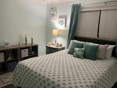 a bedroom with a large bed with green pillows at Make Your Getaway in Panama City Beach