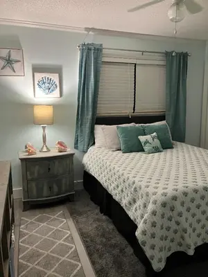 a bedroom with a bed and a table with a lamp at Make Your Getaway in Panama City Beach