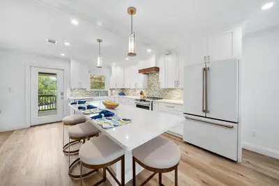 a kitchen with white cabinets and a white table and chairs at 30A Hideaway l Ocean Views l Across street from beach l Rosemary Beach in Inlet Beach