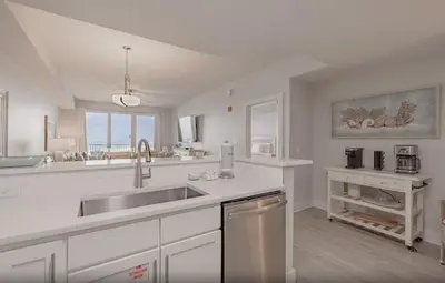 a white kitchen with a sink and a counter at Calypso 3-1006 by Emerald Coast Retreats in Panama City Beach
