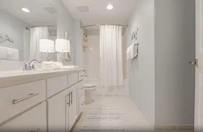 a white bathroom with a shower and a toilet at Calypso 3-1006 by Emerald Coast Retreats in Panama City Beach