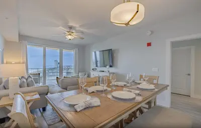 a dining room and living room with a table and chairs at Calypso 3-1006 by Emerald Coast Retreats in Panama City Beach