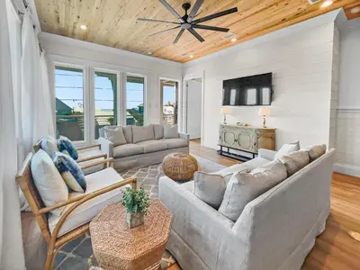 a living room with a couch and a tv at Summer Wind l Ocean Views, Steps to Beach, Private Pool and Jacuzzi, Golf Cart, Bikes, Ample Parking in Seagrove Beach