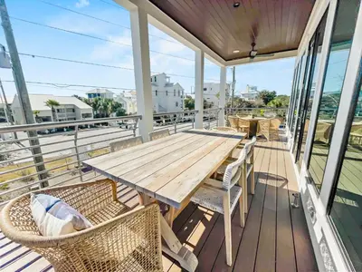 a wooden table and chairs on a balcony at Summer Wind l Ocean Views, Steps to Beach, Private Pool and Jacuzzi, Golf Cart, Bikes, Ample Parking in Seagrove Beach