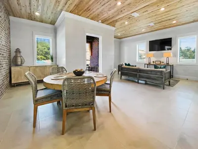 a dining room with a table and chairs and a couch at Summer Wind l Ocean Views, Steps to Beach, Private Pool and Jacuzzi, Golf Cart, Bikes, Ample Parking in Seagrove Beach