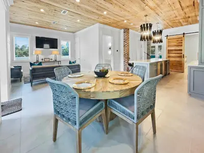 a dining room and living room with a table and chairs at Summer Wind l Ocean Views, Steps to Beach, Private Pool and Jacuzzi, Golf Cart, Bikes, Ample Parking in Seagrove Beach