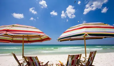 two beach chairs and umbrellas on a beach at Aqua! Under The Sea! - Beach Access! - Pool! in Seacrest