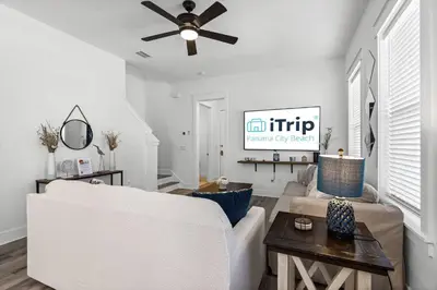 a living room with a white couch and a ceiling fan at Blue Lagoon (3/2.5) in Panama City Beach
