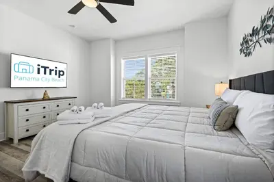 a white bedroom with a large bed and a ceiling fan at Blue Lagoon (3/2.5) in Panama City Beach