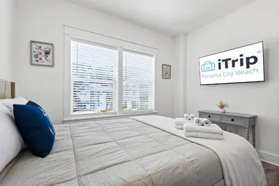 a bedroom with a large bed with a large window at Blue Lagoon (3/2.5) in Panama City Beach