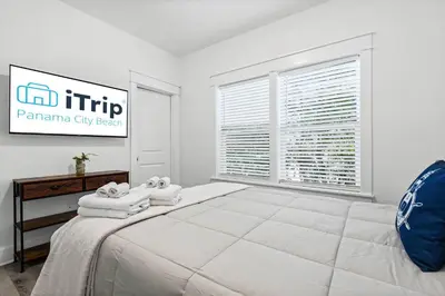 a white bedroom with a large bed and a window at Blue Lagoon (3/2.5) in Panama City Beach