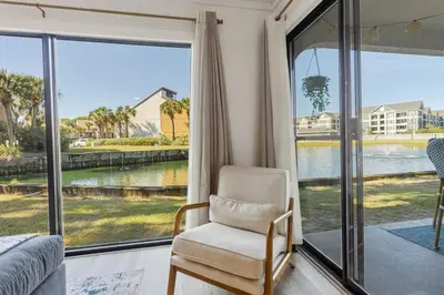 a bedroom with a chair and a large window at Edgewater Resort Villa Beach, Pools,Golf in Panama City Beach