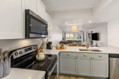 a kitchen with white cabinets and a stove top oven at Edgewater Resort Villa Beach, Pools,Golf in Panama City Beach
