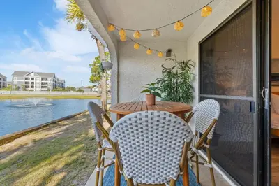 a table and chairs on a porch with a view of the water at Edgewater Resort Villa Beach, Pools,Golf in Panama City Beach