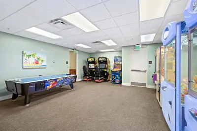 a room with a pool table and arcade games at Origin 0417 - Partial Gulf View on the Pool Desk! in Panama City Beach