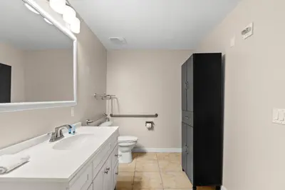 a white bathroom with a sink and a toilet at Origin 0417 - Partial Gulf View on the Pool Desk! in Panama City Beach