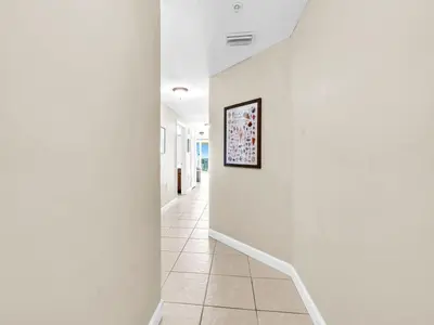 a hallway with white walls and a picture on the wall at Seychelles 2107 - The Osprey at Seychelles Resort in Panama City Beach