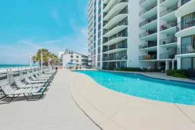 a swimming pool with chaise lounge chairs next to a building at Watercrest 110 in Panama City Beach