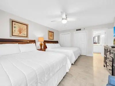 two beds in a bedroom with white sheets at Watercrest 110 in Panama City Beach