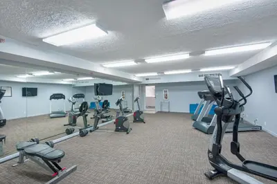 a gym with treadmills and ellipticals in a room at Watercrest 110 in Panama City Beach