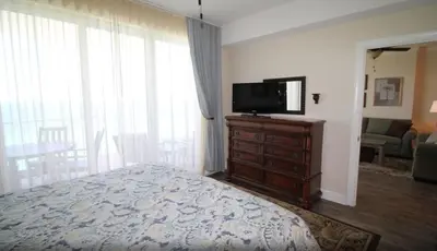 a bedroom with a bed and a flat screen tv at Emerald Isle 1406 by Emerald Coast Retreats in Panama City Beach