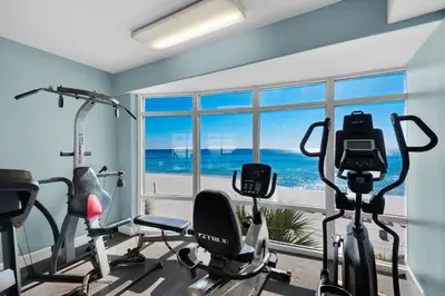 a gym with cardio equipment and a view of the ocean at Emerald Isle 1406 by Emerald Coast Retreats in Panama City Beach