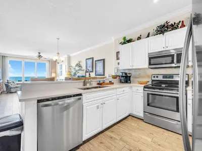 a kitchen with white cabinets and stainless steel appliances at Emerald Isle 1406 by Emerald Coast Retreats in Panama City Beach
