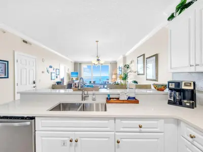 a kitchen with white cabinets and a sink at Emerald Isle 1406 by Emerald Coast Retreats in Panama City Beach