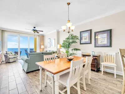 a dining room and living room with a table and chairs at Emerald Isle 1406 by Emerald Coast Retreats in Panama City Beach