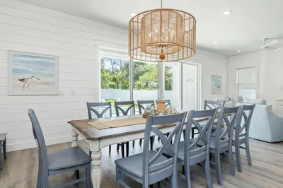 a dining room with a table and chairs and a chandelier at Luxe 8BR with Pool, Golf Cart - 2 Min to Beach in Santa Rosa Beach