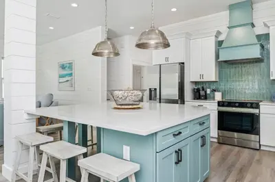 a kitchen with a blue island and white cabinets at Luxe 8BR with Pool, Golf Cart - 2 Min to Beach in Santa Rosa Beach