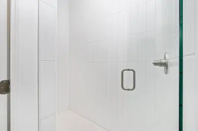a shower stall with a glass door with a shower at Luxe 8BR with Pool, Golf Cart - 2 Min to Beach in Santa Rosa Beach