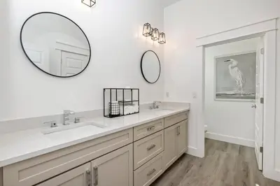 a bathroom with a sink and two mirrors on the wall at Ovation- Pool, Beach, Sleeps 21! in Santa Rosa Beach