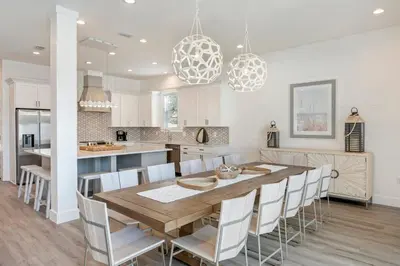 a kitchen with a wooden table and chairs at Ovation- Pool, Beach, Sleeps 21! in Santa Rosa Beach