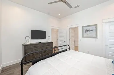 a bedroom with a bed and a flat screen tv at Ovation- Pool, Beach, Sleeps 21! in Santa Rosa Beach
