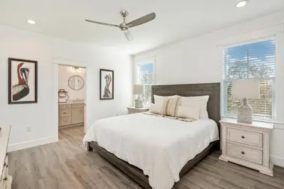 a white bedroom with a bed and a window at Ovation- Pool, Beach, Sleeps 21! in Santa Rosa Beach