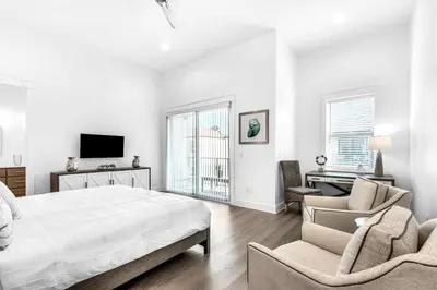 a white bedroom with a bed and chairs and a desk at NEW- Horizon! Private Beach - Golf Cart - Pool in Santa Rosa Beach