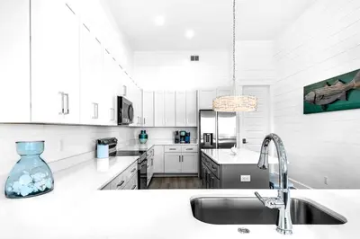 a kitchen with white cabinets and a kitchen sink at NEW- Horizon! Private Beach - Golf Cart - Pool in Santa Rosa Beach