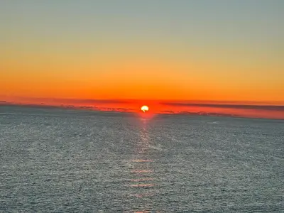 a sunset over the ocean with the sun setting at Peaks and Tide - Majestic Beach Resort in Panama City Beach