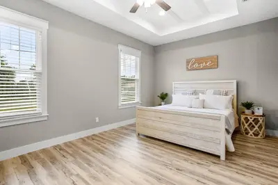 a bedroom with a bed and two windows at 4BD3BA Beach House West end PCB in Panama City Beach