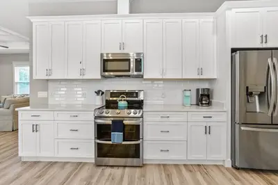 a kitchen with white cabinets and stainless steel appliances at 4BD3BA Beach House West end PCB in Panama City Beach
