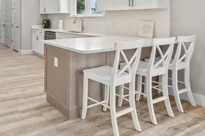 a kitchen with a white island with white stools at 4BD3BA Beach House West end PCB in Panama City Beach