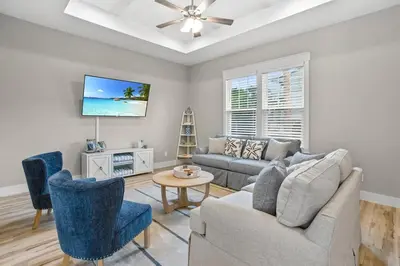 a living room with a couch and chairs and a tv at 4BD3BA Beach House West end PCB in Panama City Beach