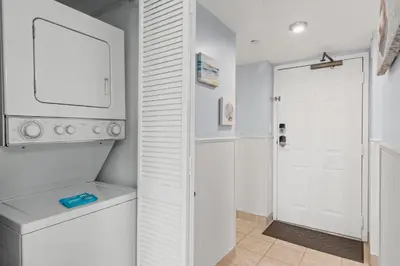 a white laundry room with a washer and dryer at Commodore 0809 in Panama City Beach