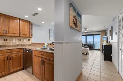 a kitchen with a sink and a refrigerator at Commodore 0809 in Panama City Beach