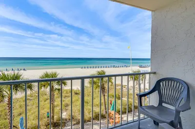 a chair sitting on a balcony overlooking the beach at Prime Beach Access and Gulf-View Balcony! PBC Condo in Panama City Beach