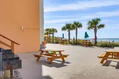 a group of picnic tables next to the beach at Prime Beach Access and Gulf-View Balcony! PBC Condo in Panama City Beach