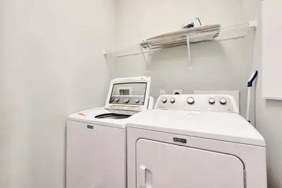 a white kitchen with a stove and a machine at Golf Cart Included - Beach - Pool - Pet Friendly in Santa Rosa Beach