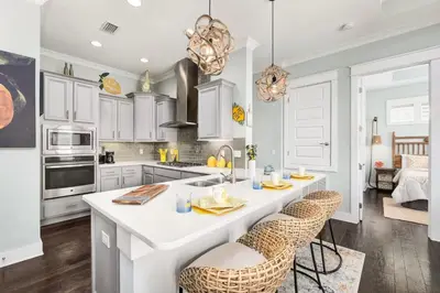 a kitchen with a large white island with bar stools at Golf Cart Included - Beach - Pool - Pet Friendly in Santa Rosa Beach